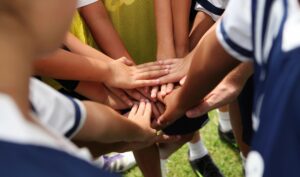 A group of children piling their hands together