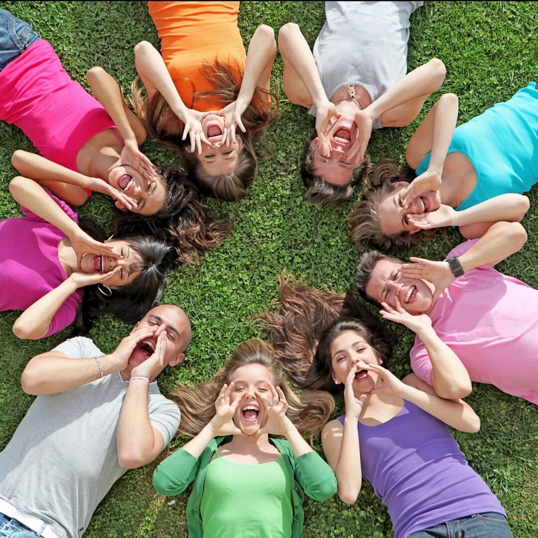 A group of people lying down on a grassy surface